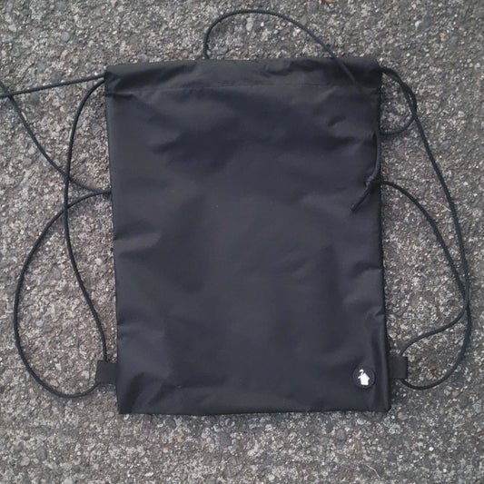 Black drawstring bag on a textured surface