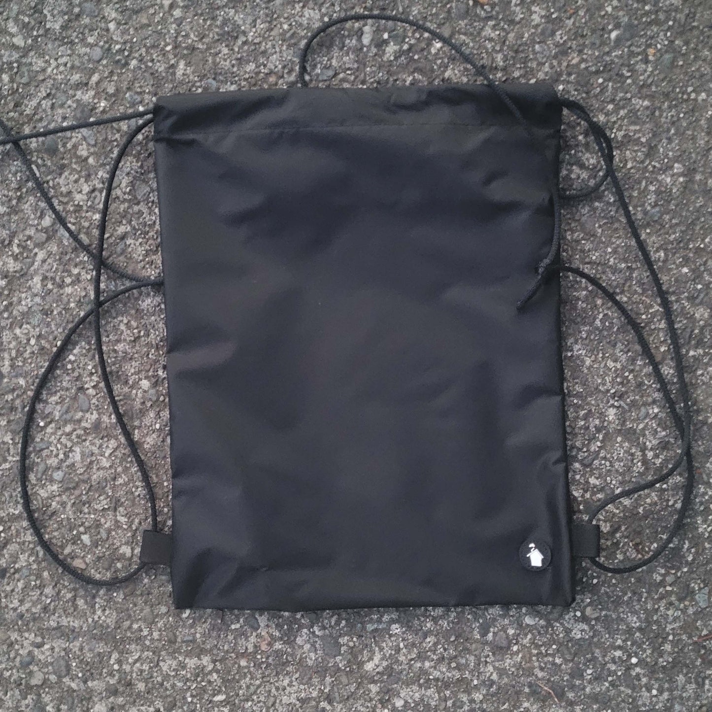 Black drawstring bag on a textured surface