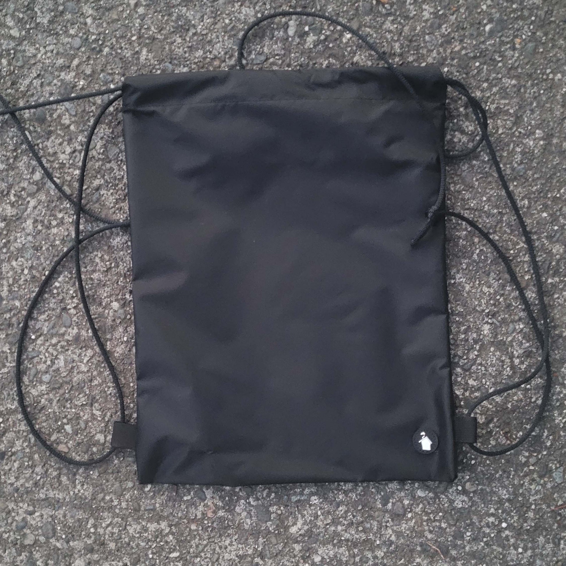 Black drawstring bag on a textured surface
