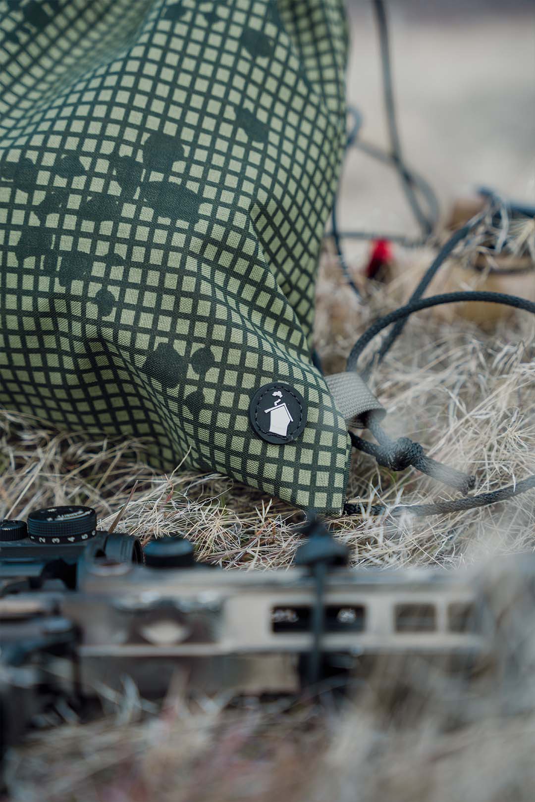 Green checkered bag with a brand logo on a grassy background